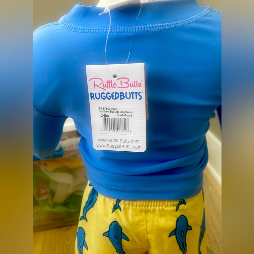 Long sleeve blue Rugged Butts Sz 3-6 months.  Shark trunks, yellow and blue.
